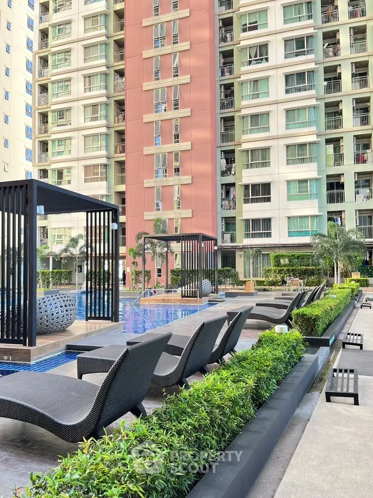 Luxurious apartment complex with poolside cabanas and modern architecture.