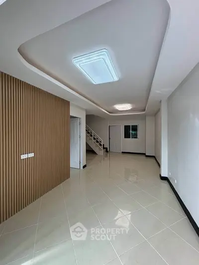 Spacious modern living room with elegant ceiling design and staircase