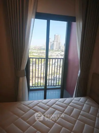 Cozy bedroom with balcony offering stunning city view, perfect for urban living.
