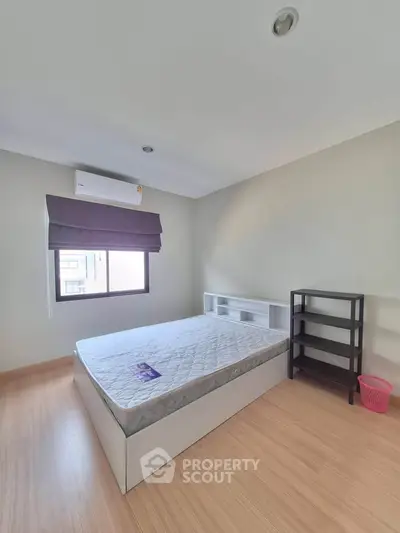 Spacious bedroom with natural light, featuring a comfortable bed and modern furnishings.
