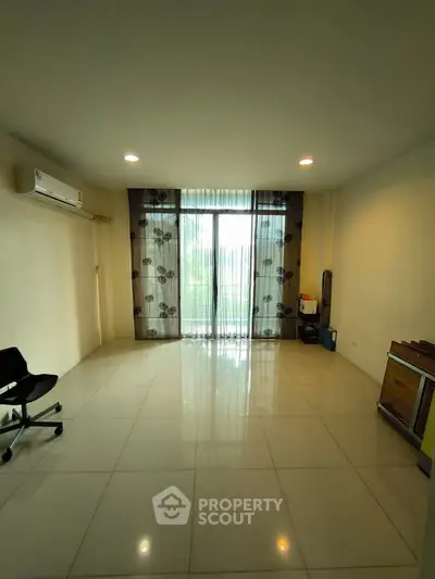 Spacious living room with large window and air conditioning, ideal for modern living.