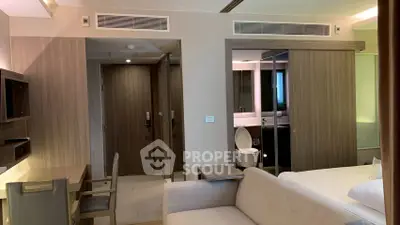Modern hotel room with sleek design, featuring a cozy bed, work desk, and stylish bathroom.