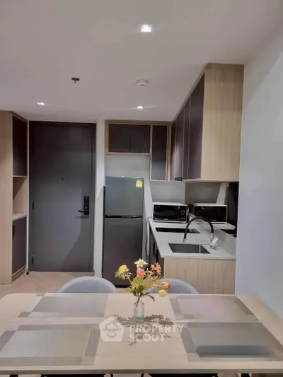 Modern kitchen with sleek cabinetry and dining area in a stylish apartment.