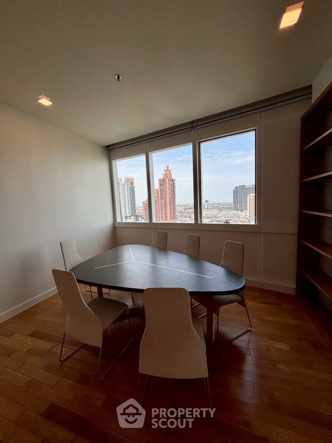 Spacious study room with city view, featuring a modern table and chairs, perfect for work or meetings.