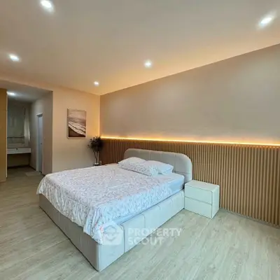 Spacious modern bedroom with elegant lighting and cozy decor