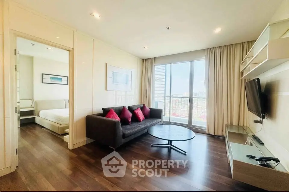 Spacious modern living room with city view, featuring sleek furniture and natural light.