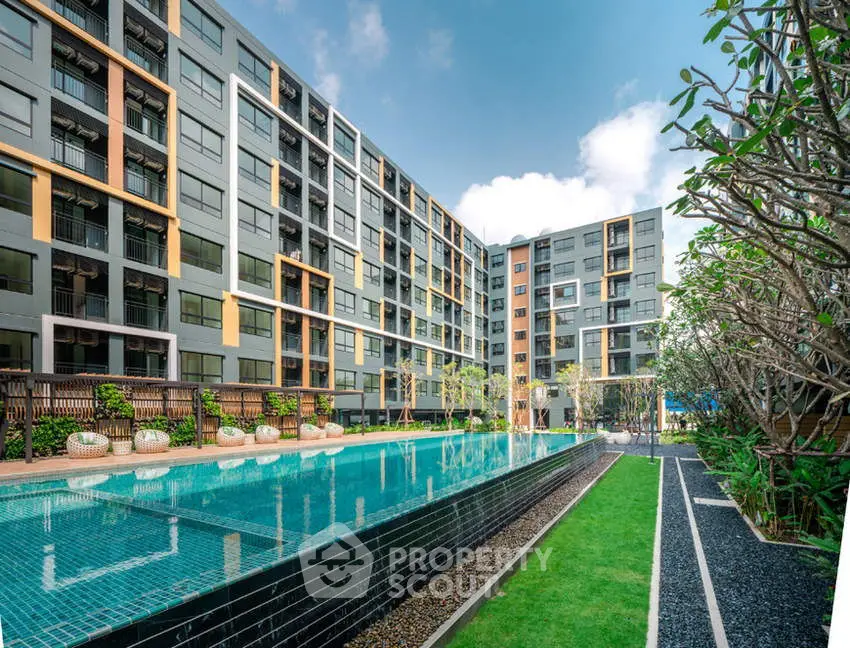 Modern apartment complex with a stunning outdoor pool and lush landscaping.