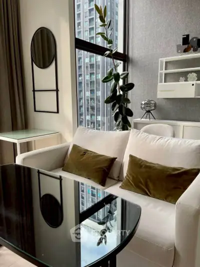 Modern living room with stylish decor and large window view in urban apartment.