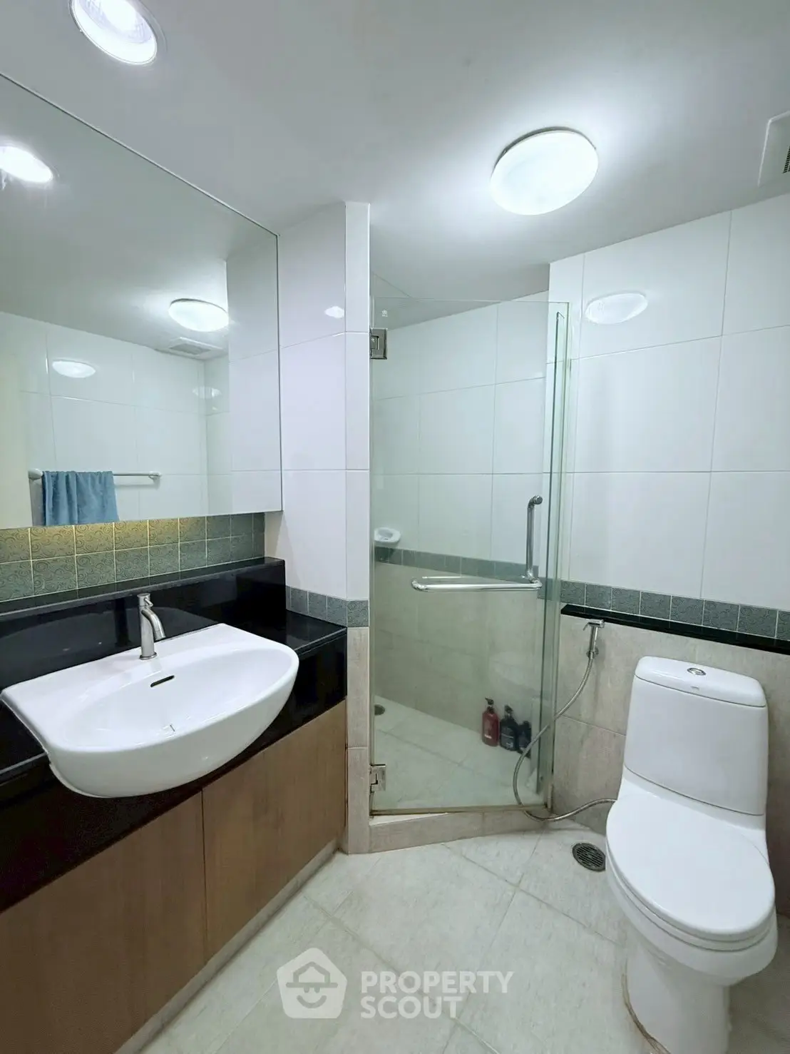 Modern bathroom with glass shower and sleek fixtures in stylish apartment.