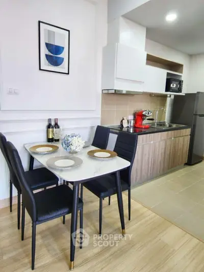 Modern kitchen with dining area, featuring sleek cabinetry and stylish decor.