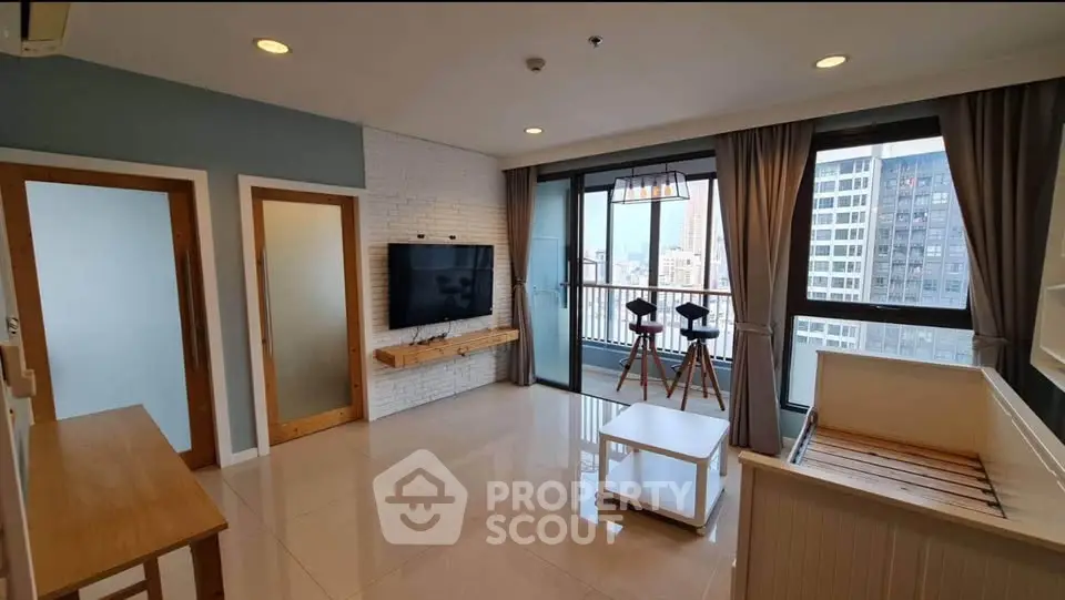 Modern living room with large windows and city view, featuring stylish decor and ample natural light.