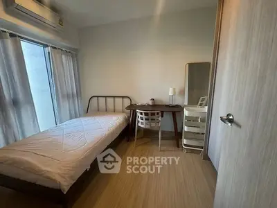 Cozy minimalist bedroom with single bed, desk, and natural light from large window.