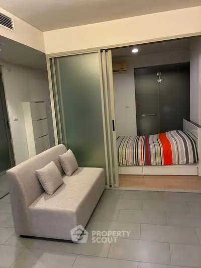 Modern studio apartment with sliding glass doors and cozy sofa