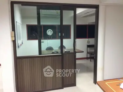 Modern office space with glass partition and air conditioning, ideal for meetings and collaborative work.