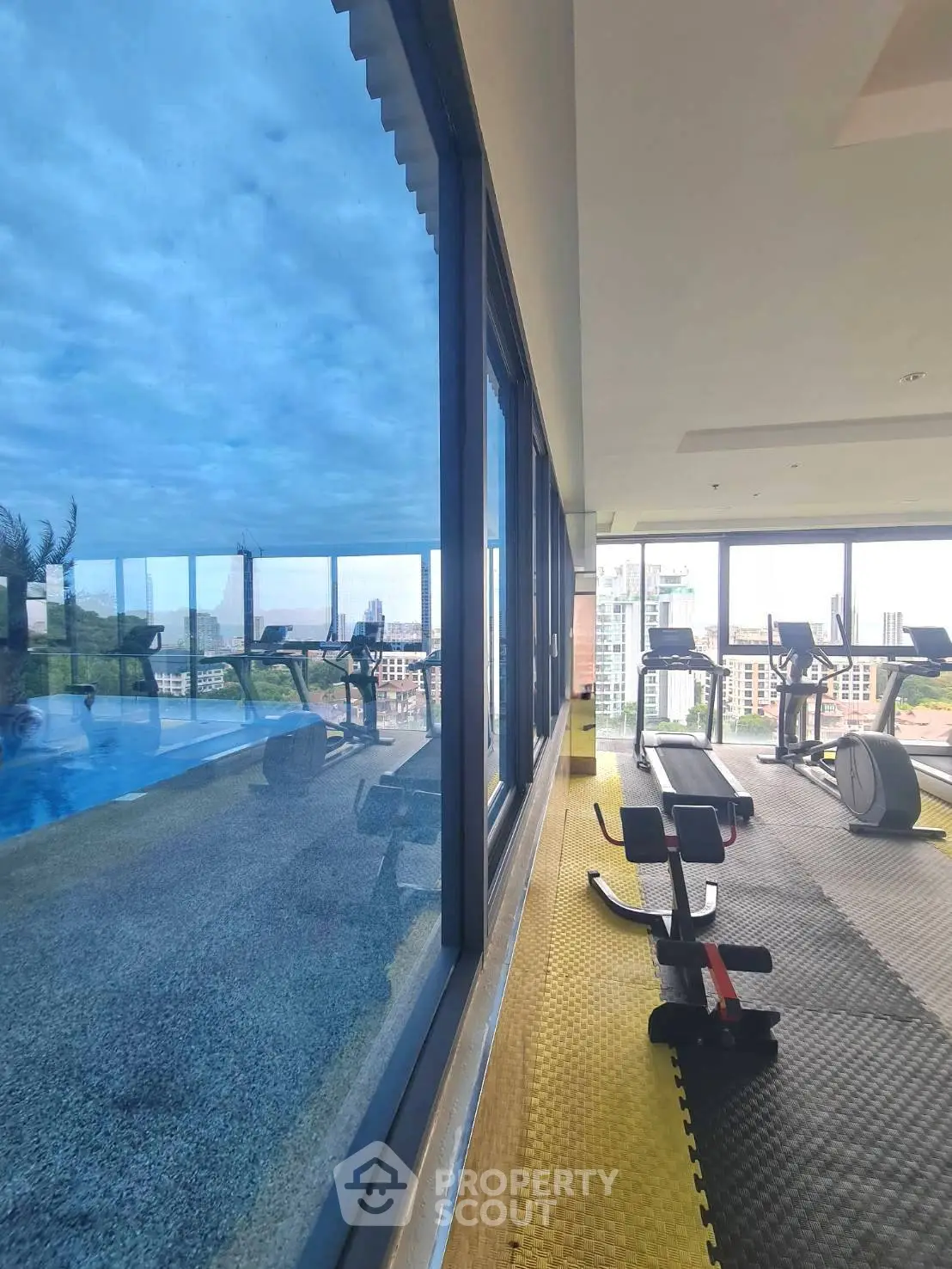 Modern gym with panoramic city views and state-of-the-art fitness equipment.