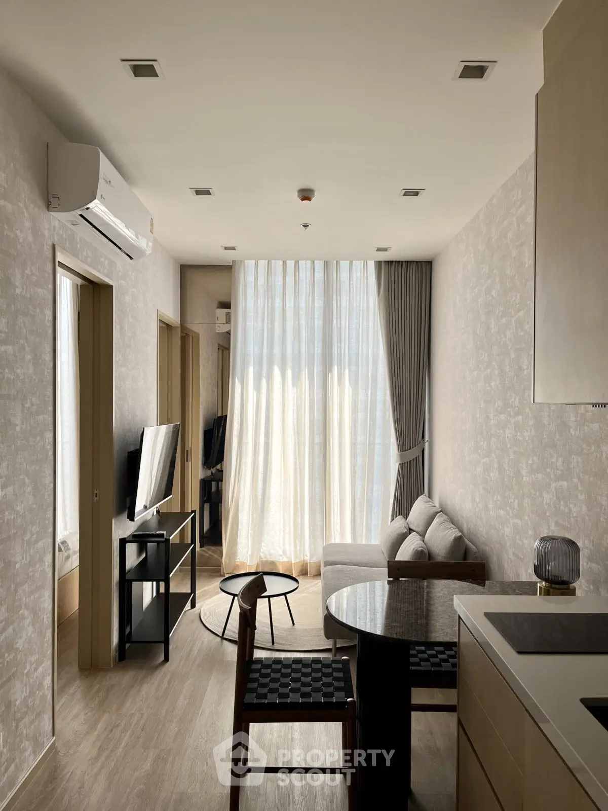 Modern living room with natural light, cozy sofa, and sleek furniture in a stylish apartment.