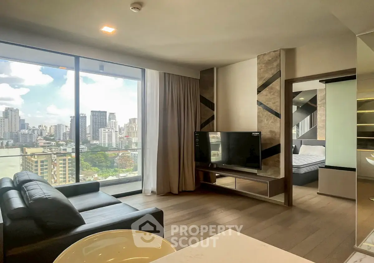 Modern living room with city view, sleek furniture, and large windows in urban apartment.