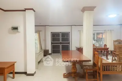 Spacious living area with elegant wooden furniture and large windows for natural light.