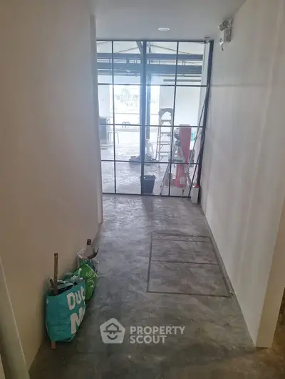 Modern industrial hallway with glass doors and concrete flooring