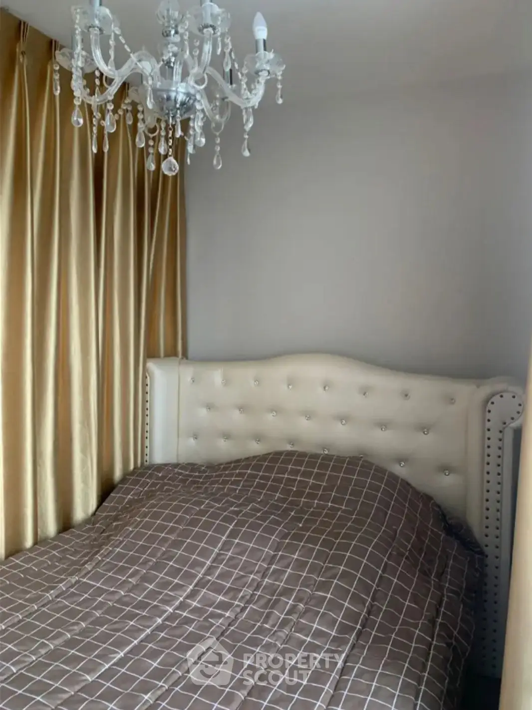Luxurious bedroom with elegant chandelier and plush headboard