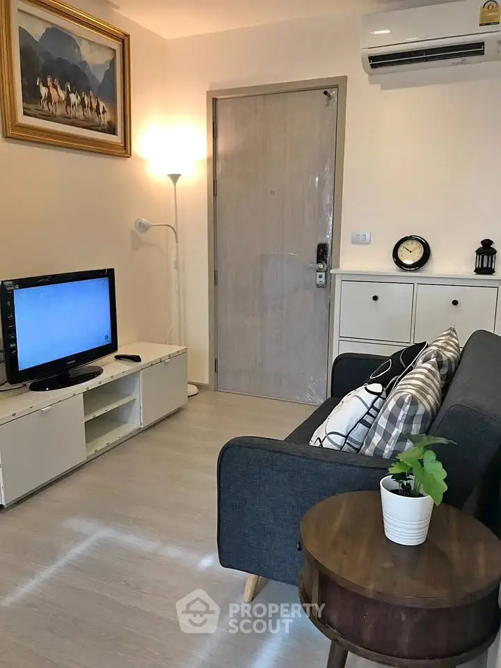 Cozy living room with modern decor, featuring a TV, sofa, and air conditioning for comfortable living.