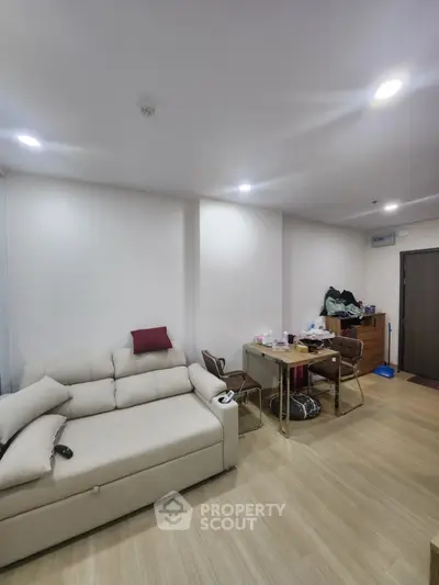 Modern living room with cozy sofa and dining table in open layout apartment
