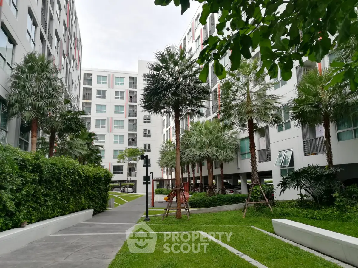 Modern apartment complex with lush green landscaping and palm trees