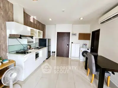 Modern open-layout kitchen with sleek appliances and dining area in a bright apartment.