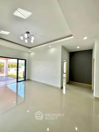 Spacious modern living room with elegant lighting and large sliding doors to patio.