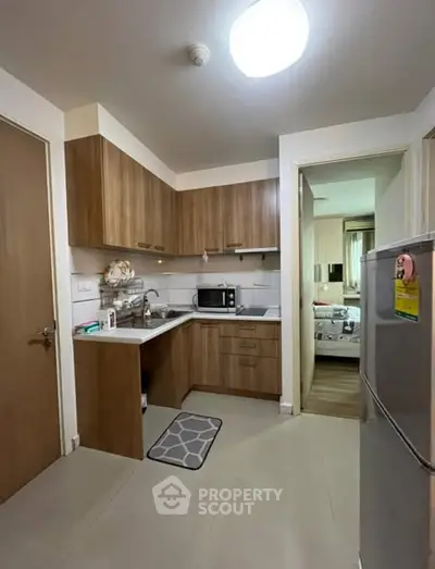 Cozy kitchen with wooden cabinets and modern appliances in a compact layout.