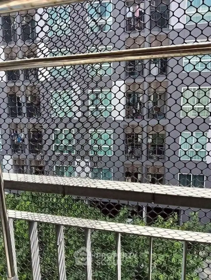 Modern apartment building view through safety netting on balcony.