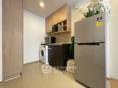Modern kitchen with washing machine and fridge in compact layout