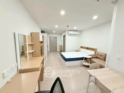 Modern studio apartment with sleek furniture and ample lighting
