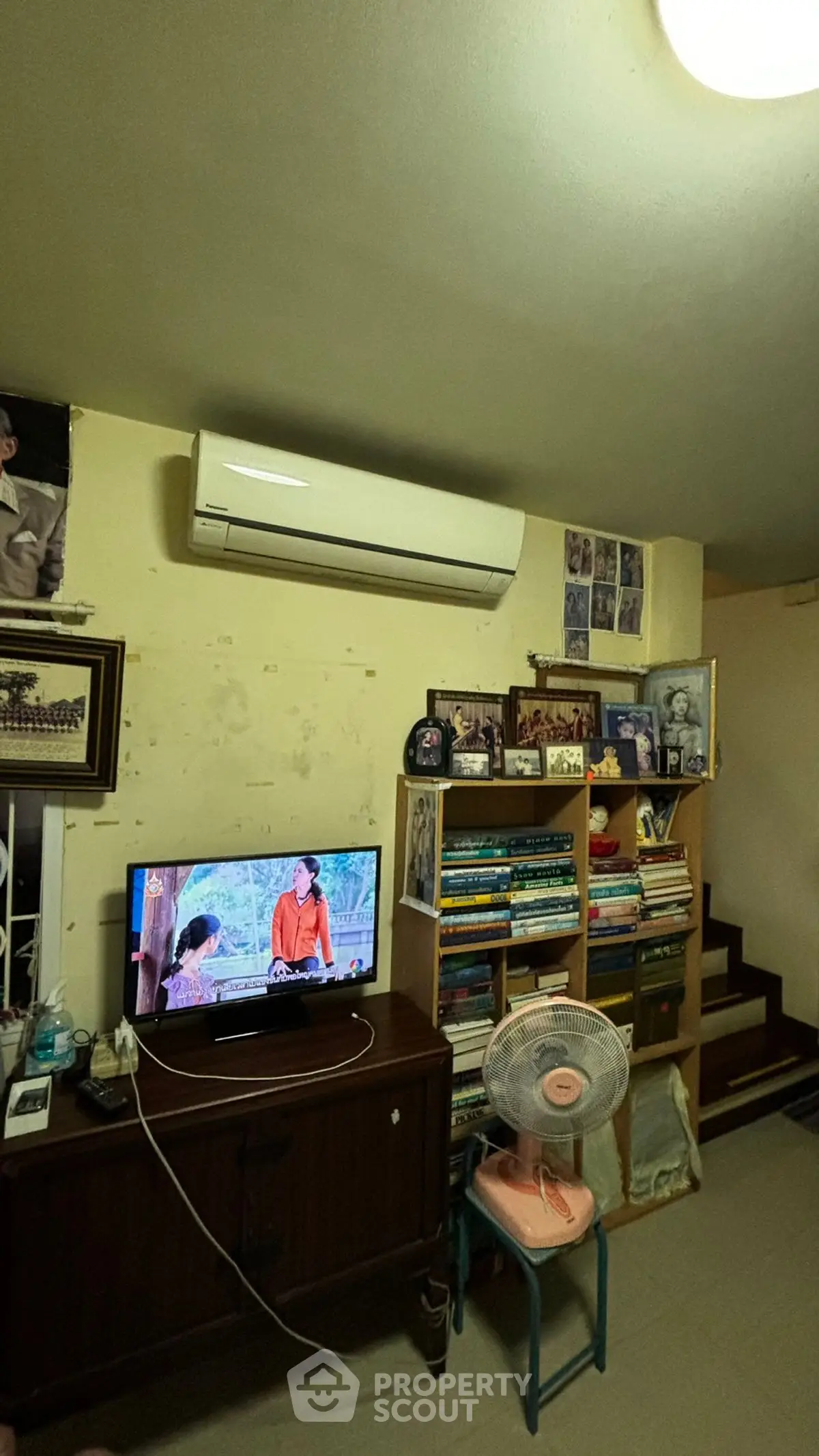 Cozy living room with air conditioning and bookshelf, perfect for relaxation.