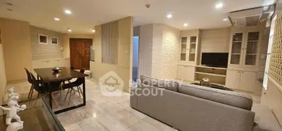 Spacious modern living room with dining area, featuring elegant decor and ample natural light.