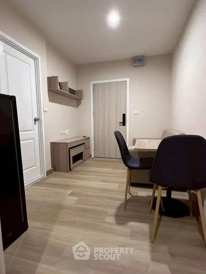 Modern dining area with sleek furniture and wooden flooring in a cozy apartment.