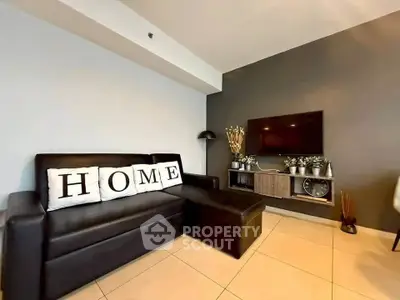 Modern living room with sleek black sofa and wall-mounted TV