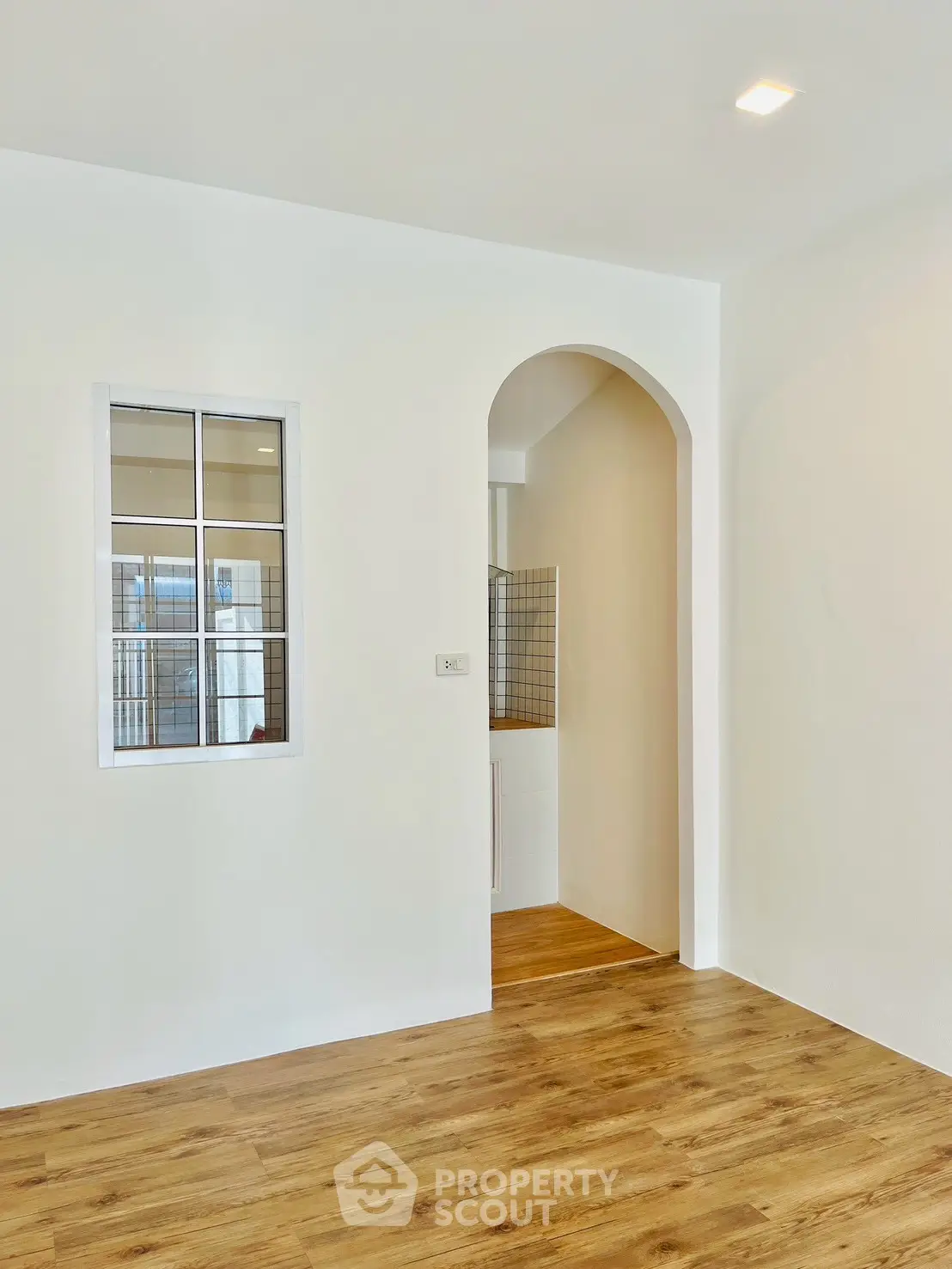 Modern interior with wooden flooring and arched doorway
