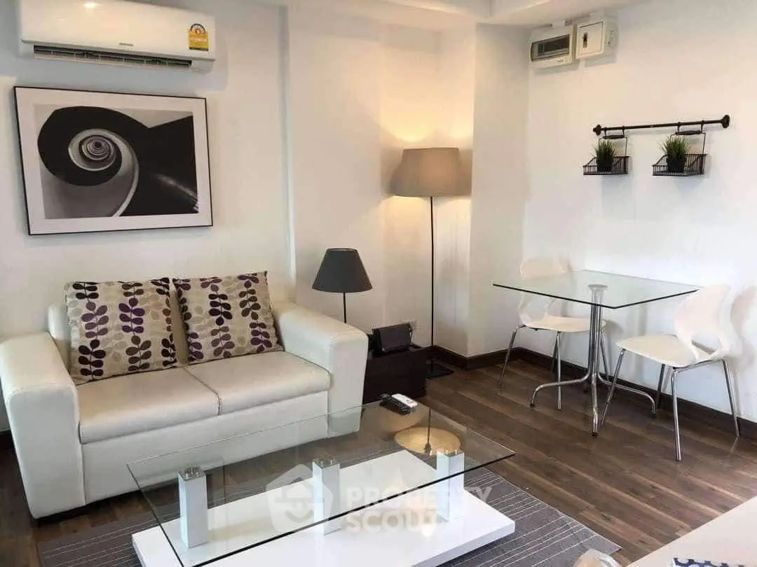 Modern living room with stylish decor, glass coffee table, and cozy seating area.