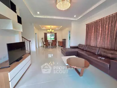 Spacious modern living room with elegant chandelier and cozy dining area