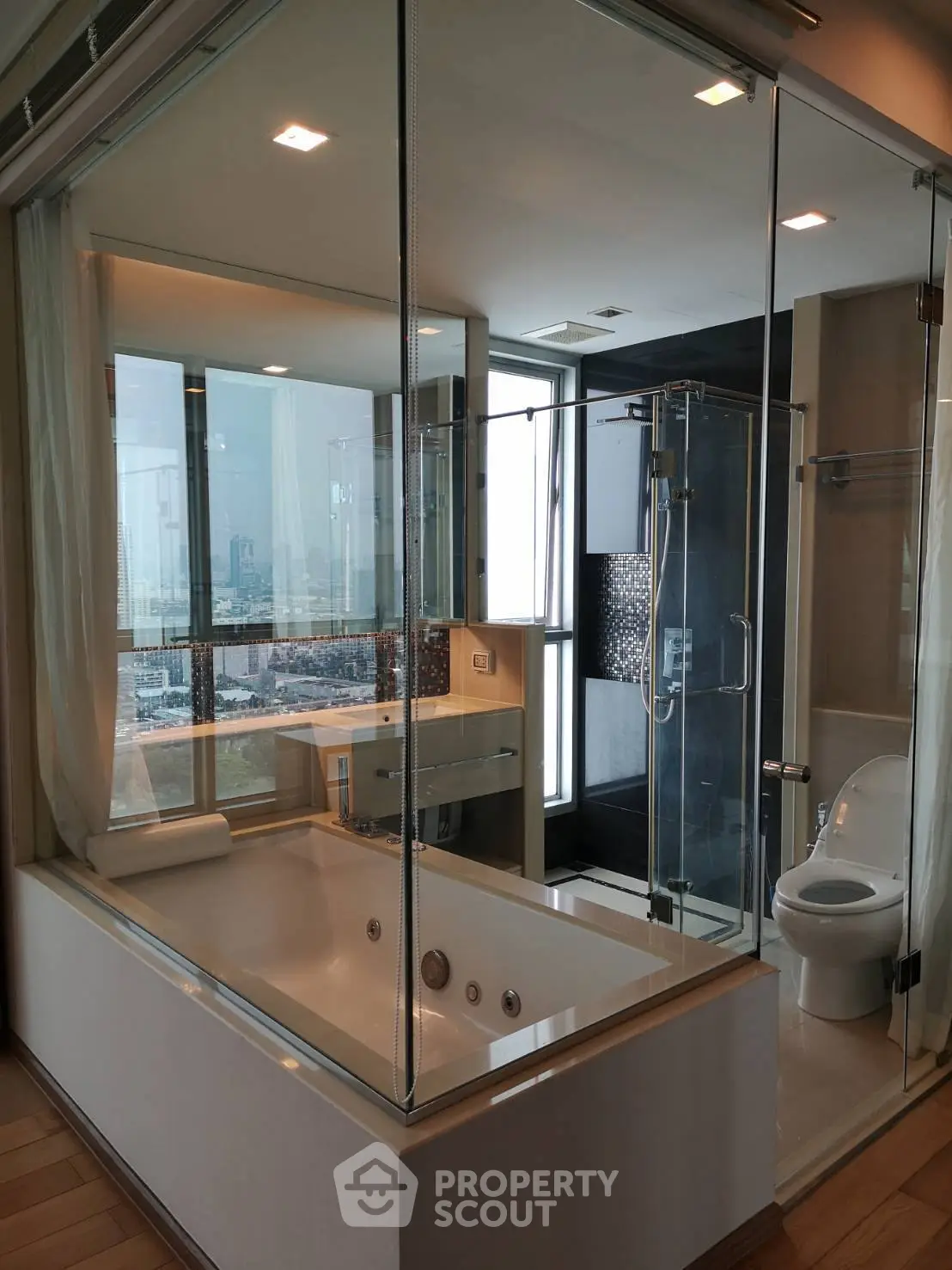 Luxurious bathroom with city view, featuring a glass-enclosed bathtub and modern fixtures.