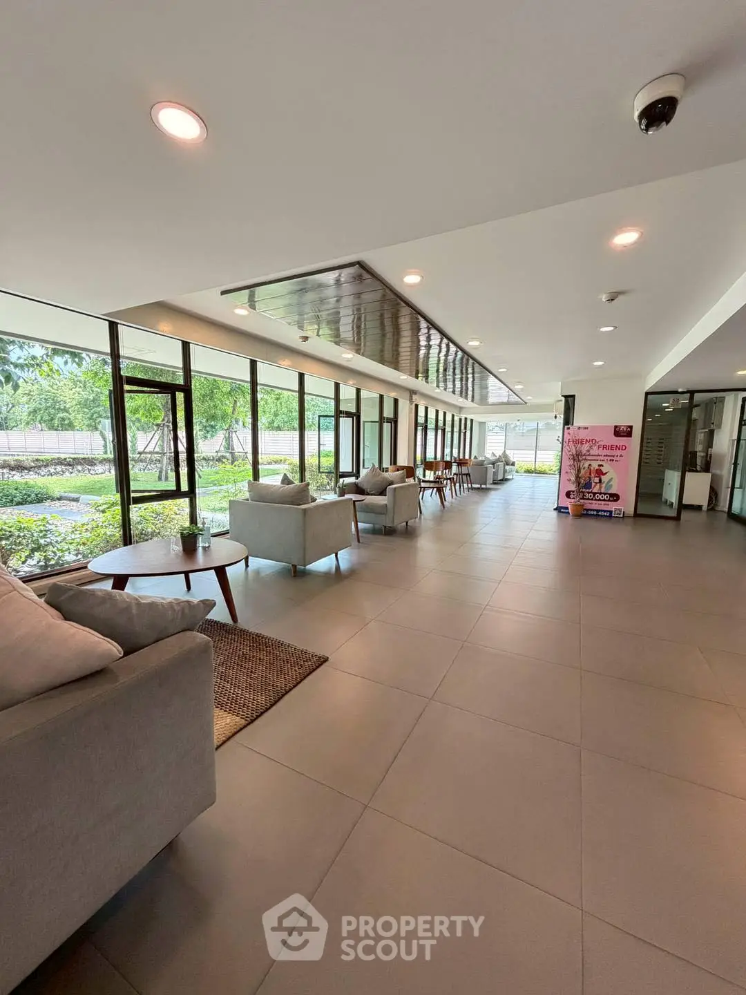 Spacious and modern lobby with comfortable seating and large windows offering garden views.