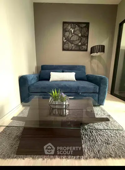 Modern living room with stylish blue sofa and elegant glass coffee table
