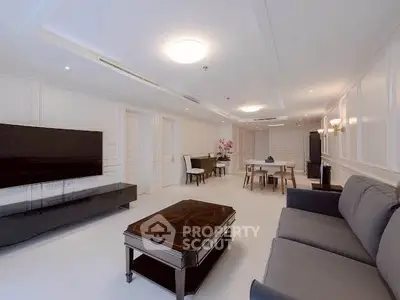 Spacious modern living room with elegant decor and large flat-screen TV, perfect for relaxation and entertainment.