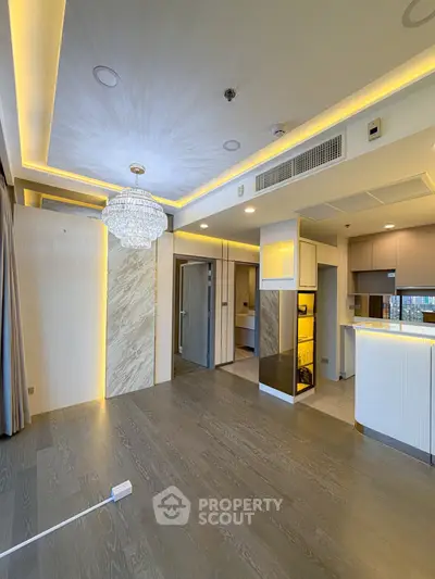 Luxurious modern living room with elegant chandelier and open kitchen layout