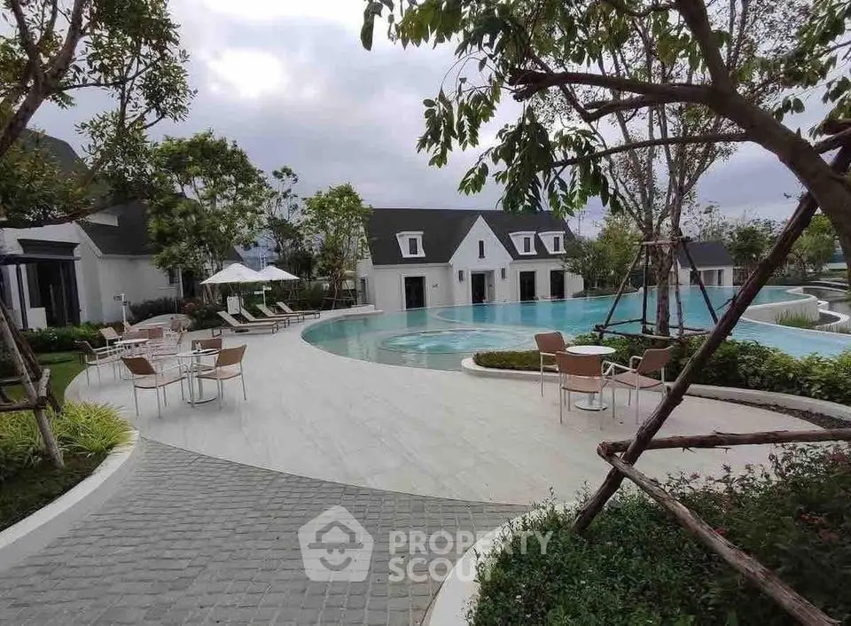 Luxurious outdoor pool area with modern seating and lush greenery, perfect for relaxation and leisure.