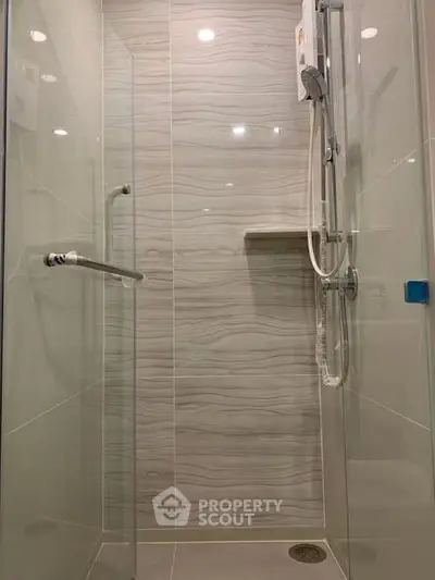 Modern shower area with sleek glass doors and elegant tile design