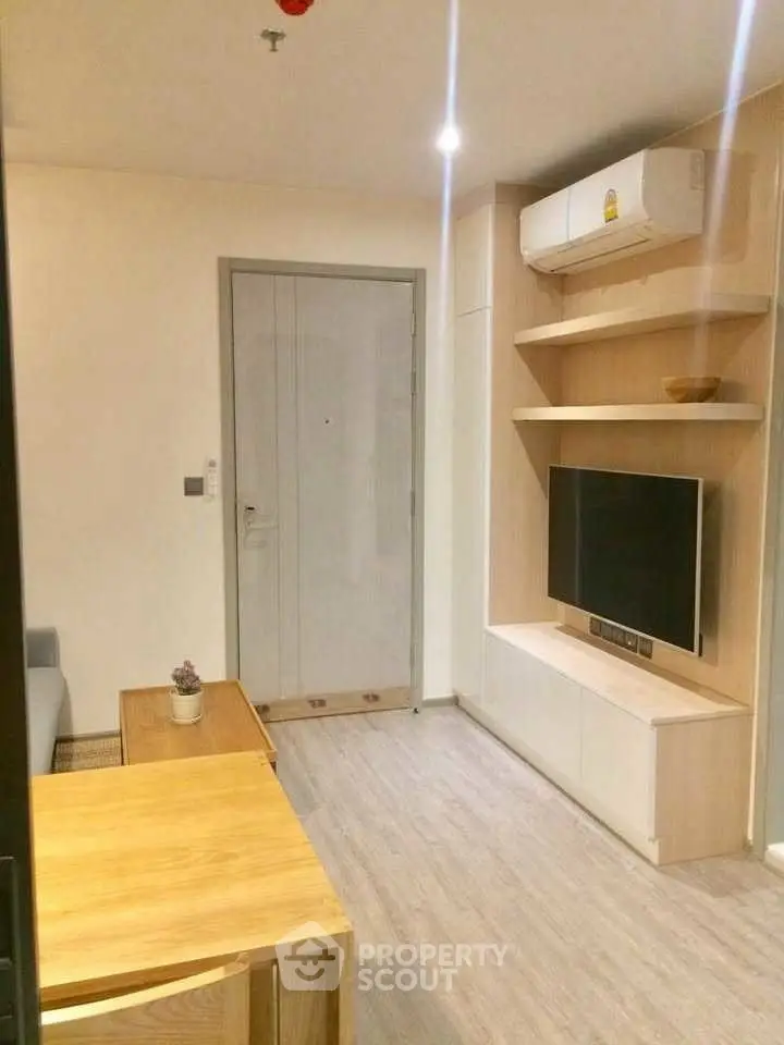 Modern living room with sleek wooden furniture and mounted TV, perfect for cozy relaxation.
