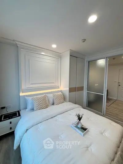 Modern bedroom with elegant decor and soft lighting, featuring a cozy bed and stylish storage solutions.