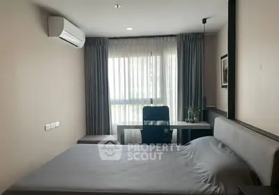 Modern bedroom with sleek design, featuring a comfortable bed, desk, and air conditioning.